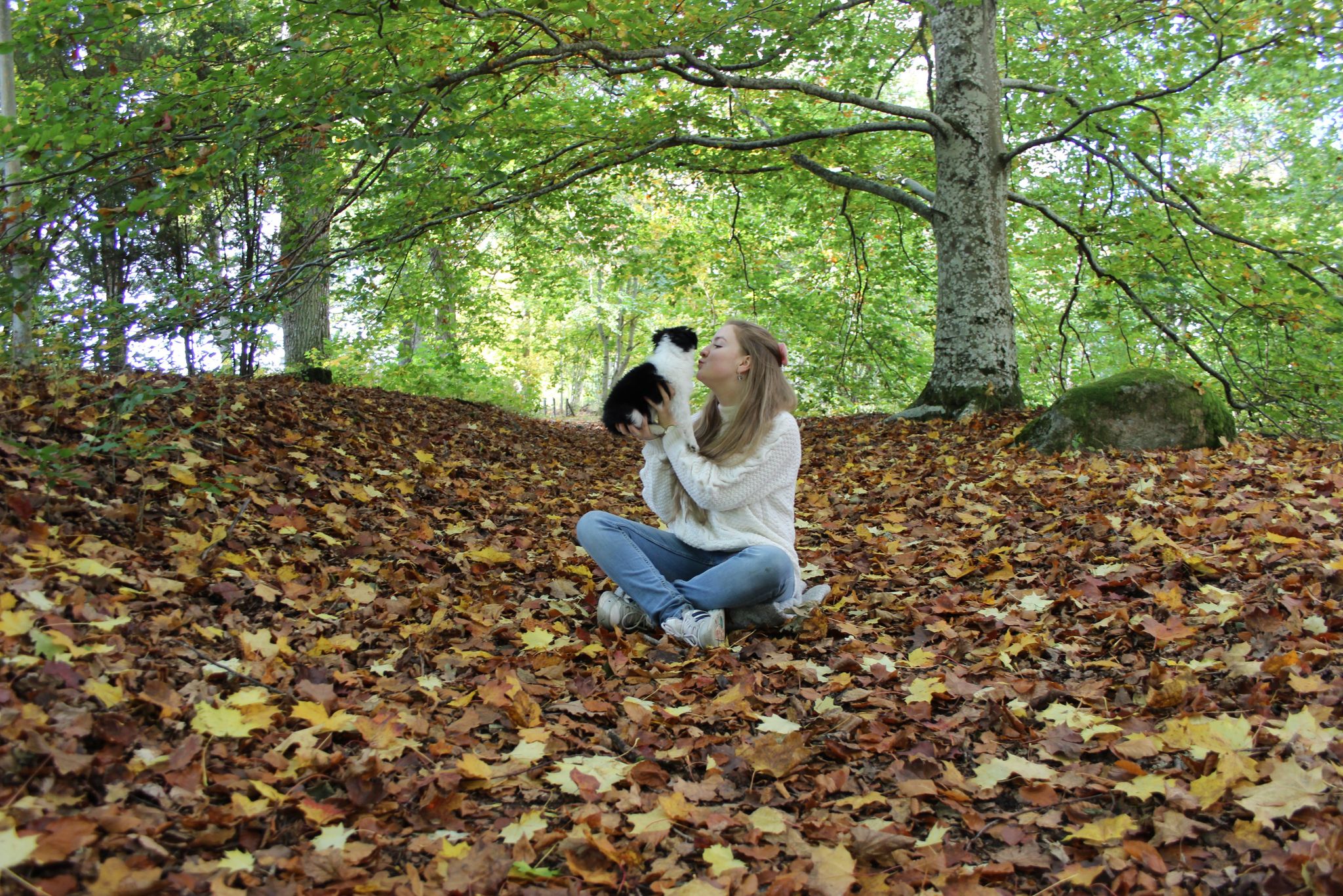 Emma tillsammans med hunden Lilja i höstskogen